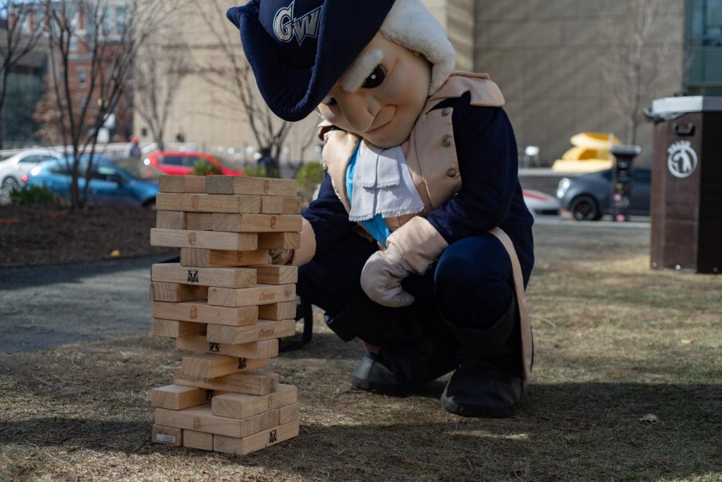 George plays a game of Jenga at the GW Palooza tailgate Sunday before attending the women's basketball homecoming game against George Mason.