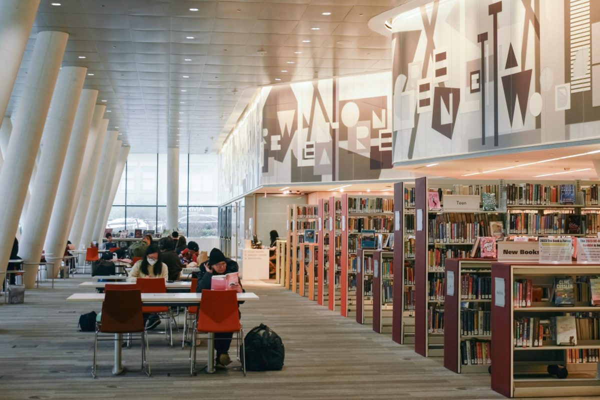 Readers lounge at tables in the West End Library.