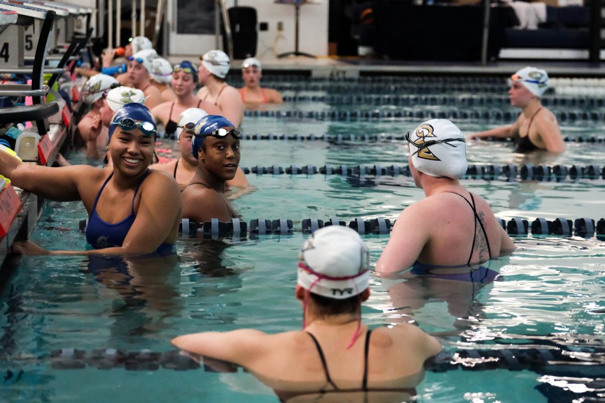 A swimmer smiles in the pool during a practice earlier this season.